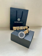 Versace belt with dark leather and gold baroque print, circular V buckle on box
