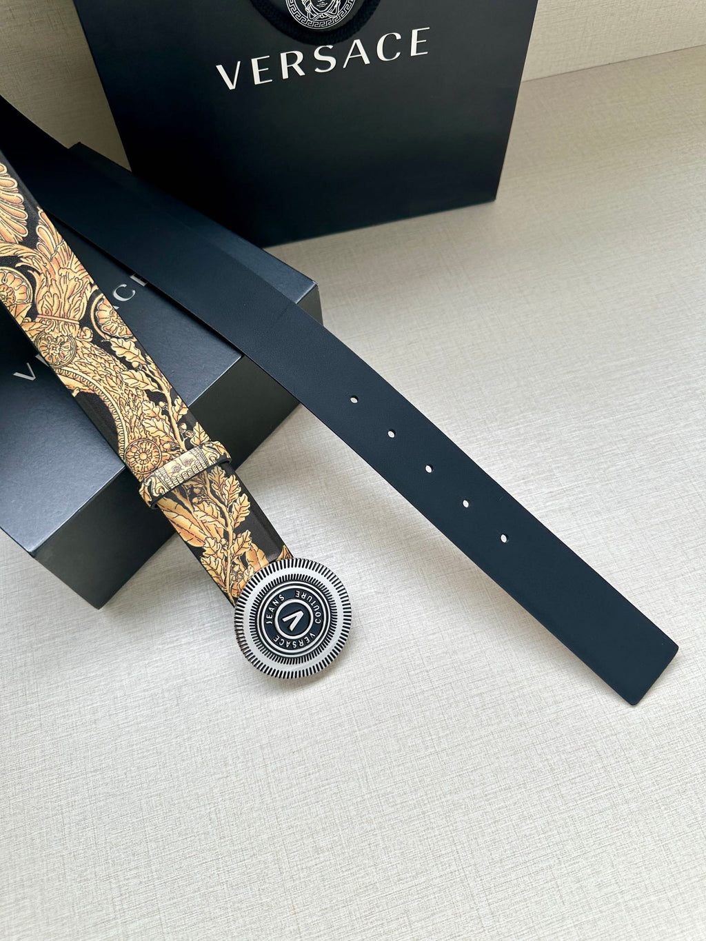 Versace belt: long dark strap with gold print, round buckle and belt holes