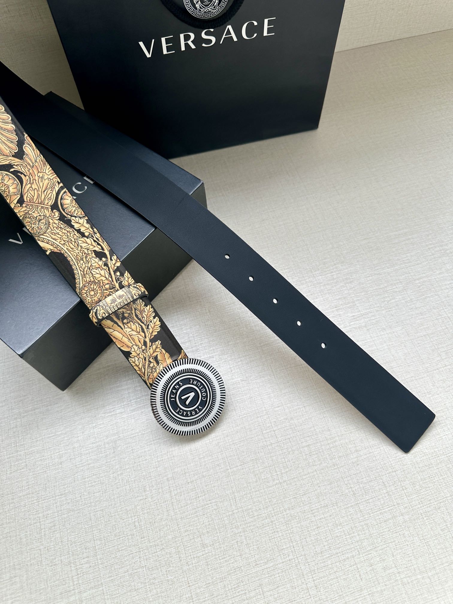 Versace belt: long dark strap with gold print, round buckle and belt holes