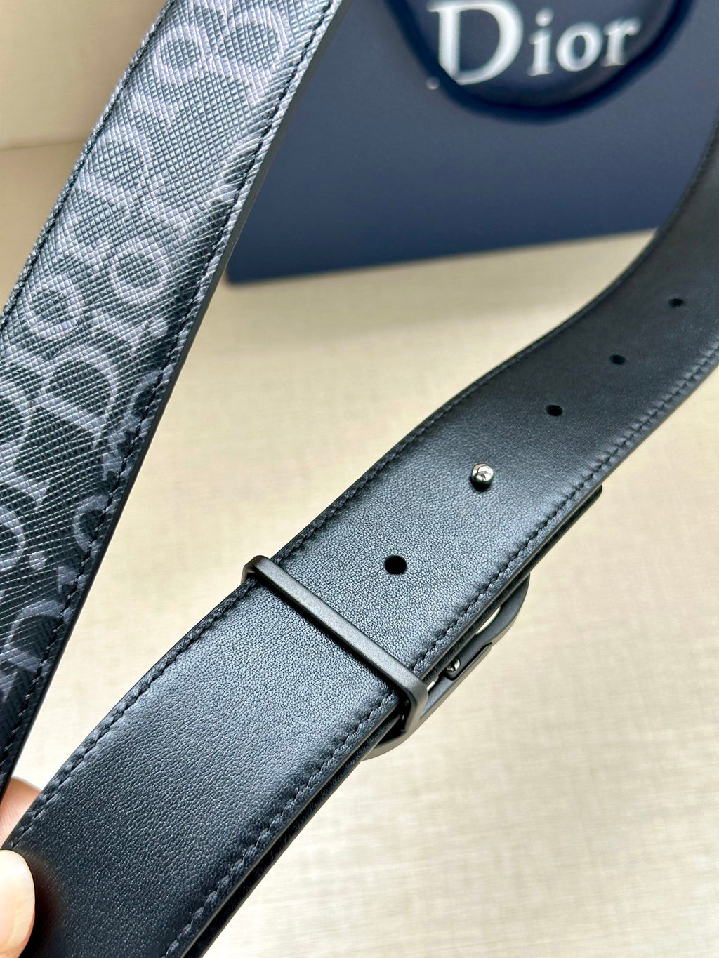 Dior belt with smooth dark blue leather strap, silver buckle, and punched holes