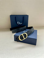 Dior belt with dark monogram strap and gold CD buckle, laid on box