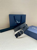 Dior belt with dark monogram strap and black CD buckle, styled on box