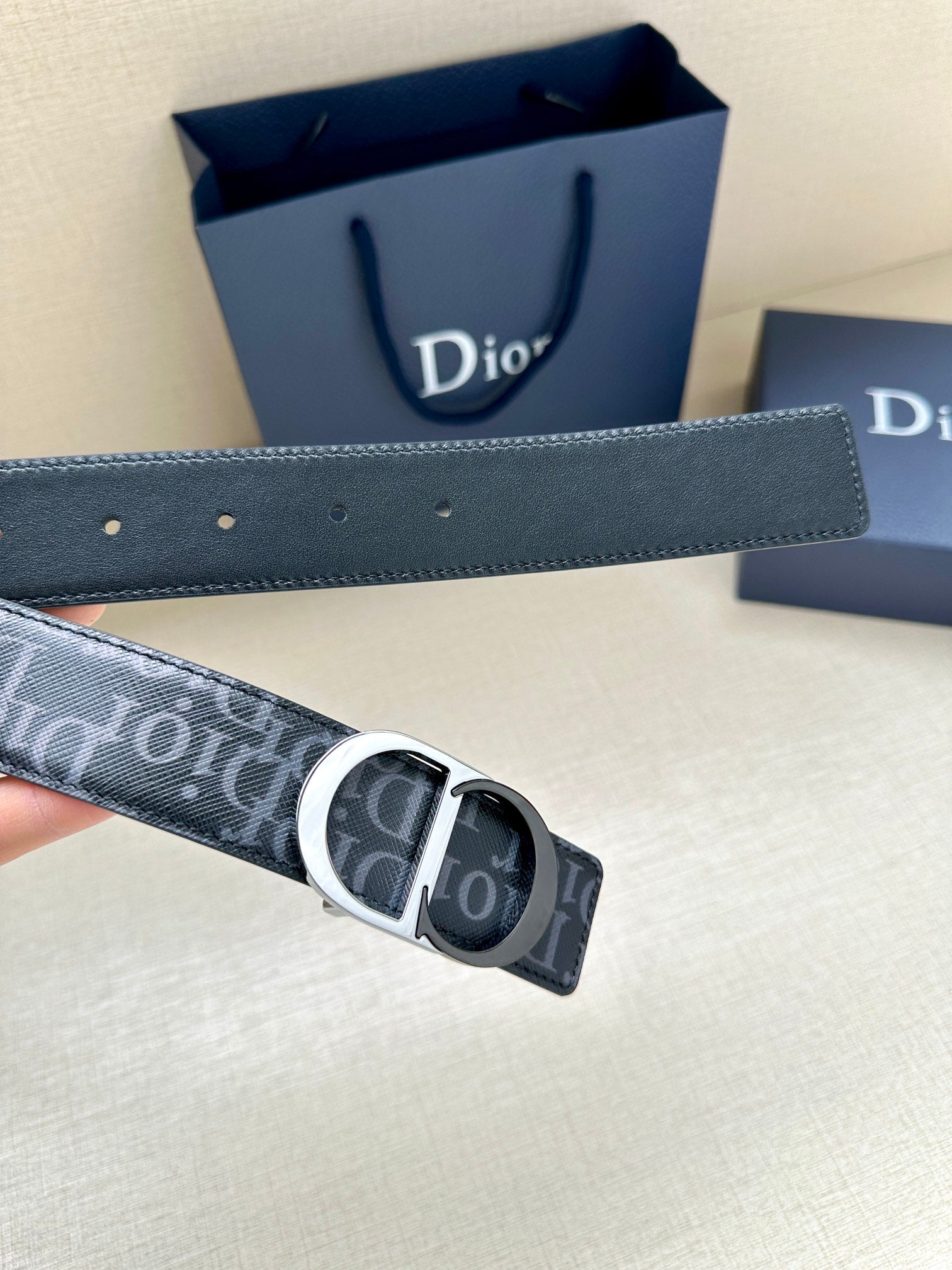 Dior Oblique belt close-up with silver CD buckle on dark blue strap