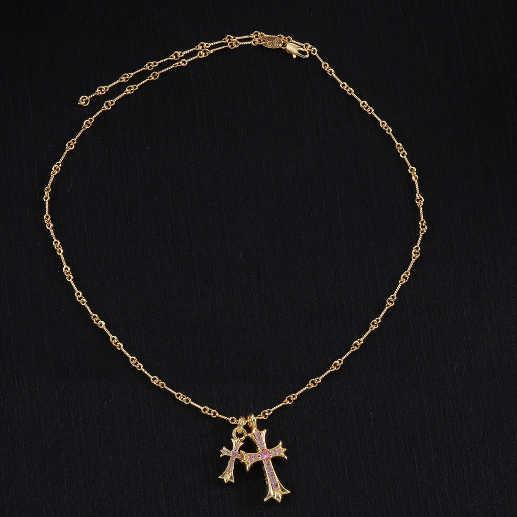 Gold cross pendant necklace with purple stone accents and linked chain