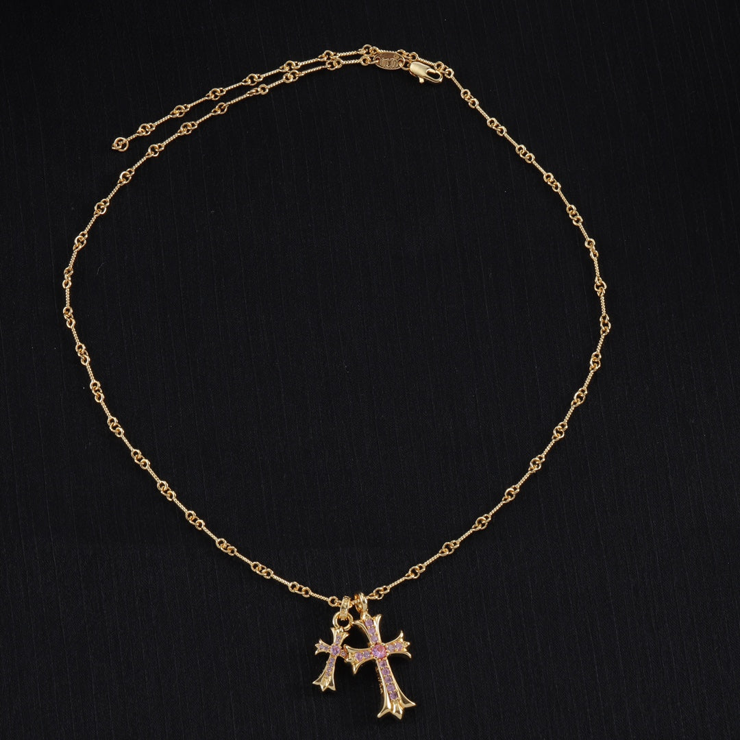 Gold cross pendant necklace with purple stone accents and linked chain
