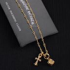 Gold-tone chain necklace with cross and star charms and round charm pendant