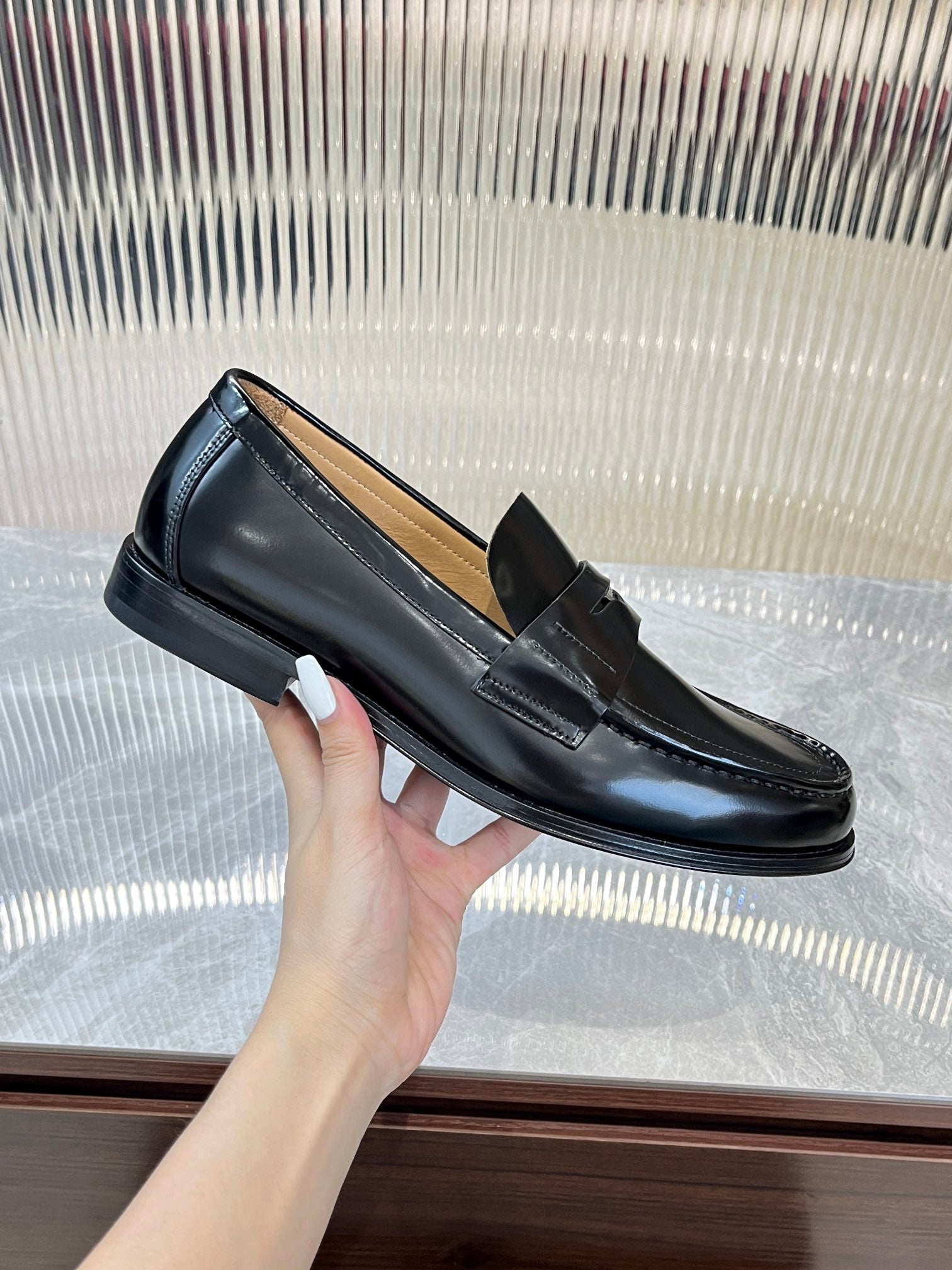 Prada unisex black leather loafer held at side, metal strap and low block heel.
