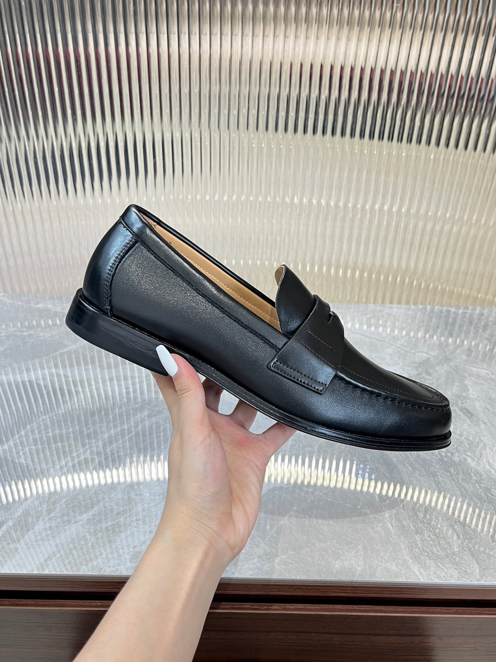 Prada unisex leather loafer, dark color, side profile with strap and low sole