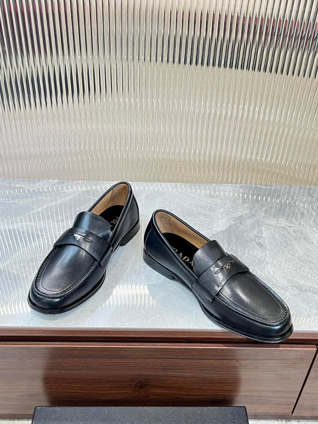 Prada unisex leather loafers, dark color, side view with strap detail