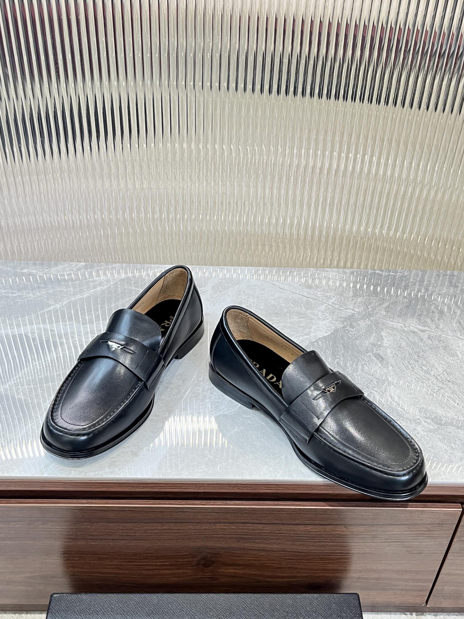 Prada unisex leather loafers, dark color, side view with strap detail