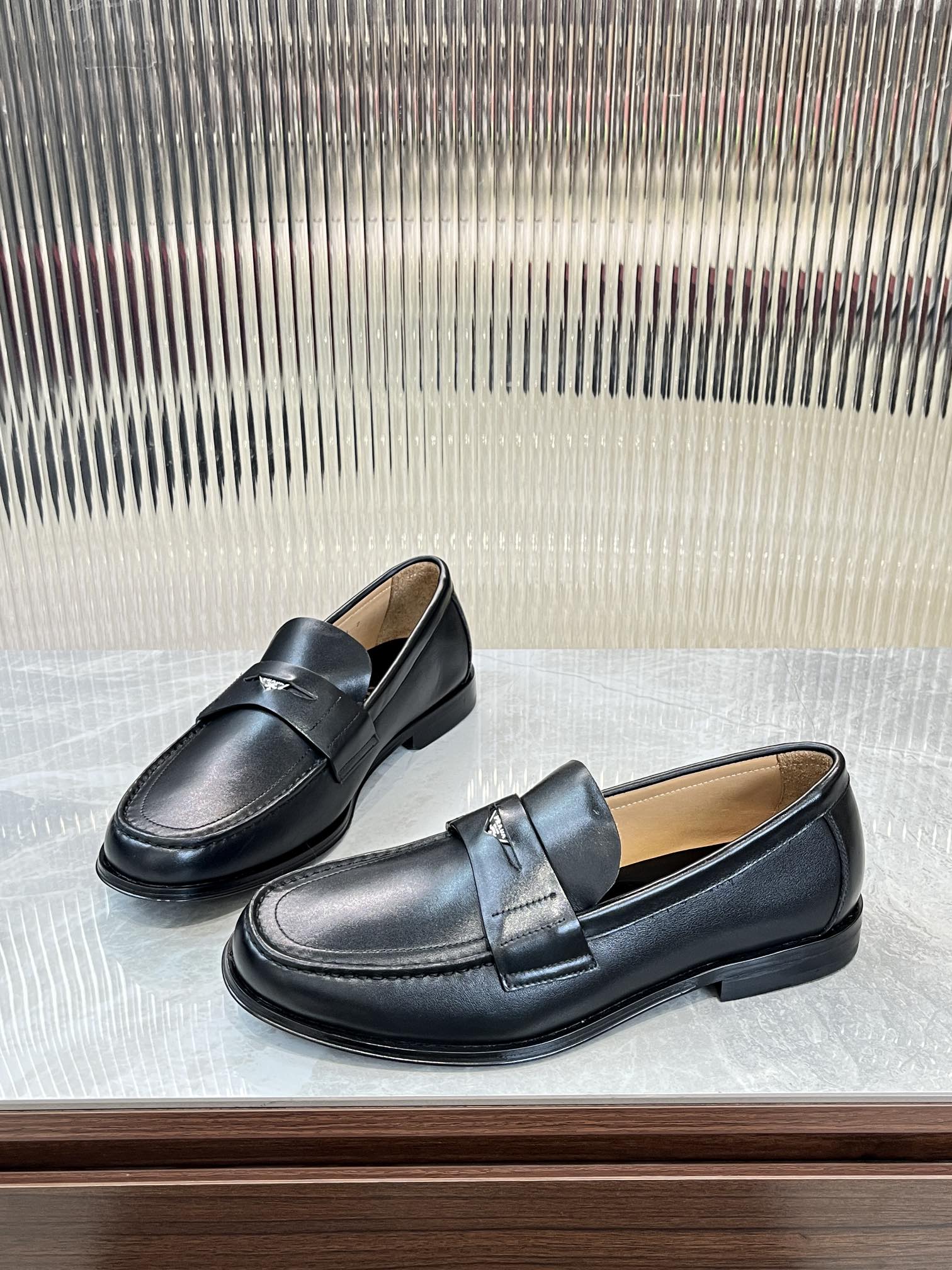 Prada unisex leather loafers, dark color, angled side view with strap detail