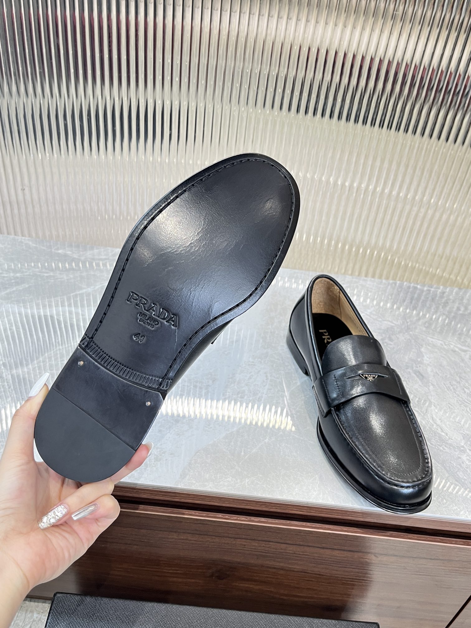 Prada unisex leather loafers, dark color; outsole and strap vamp visible