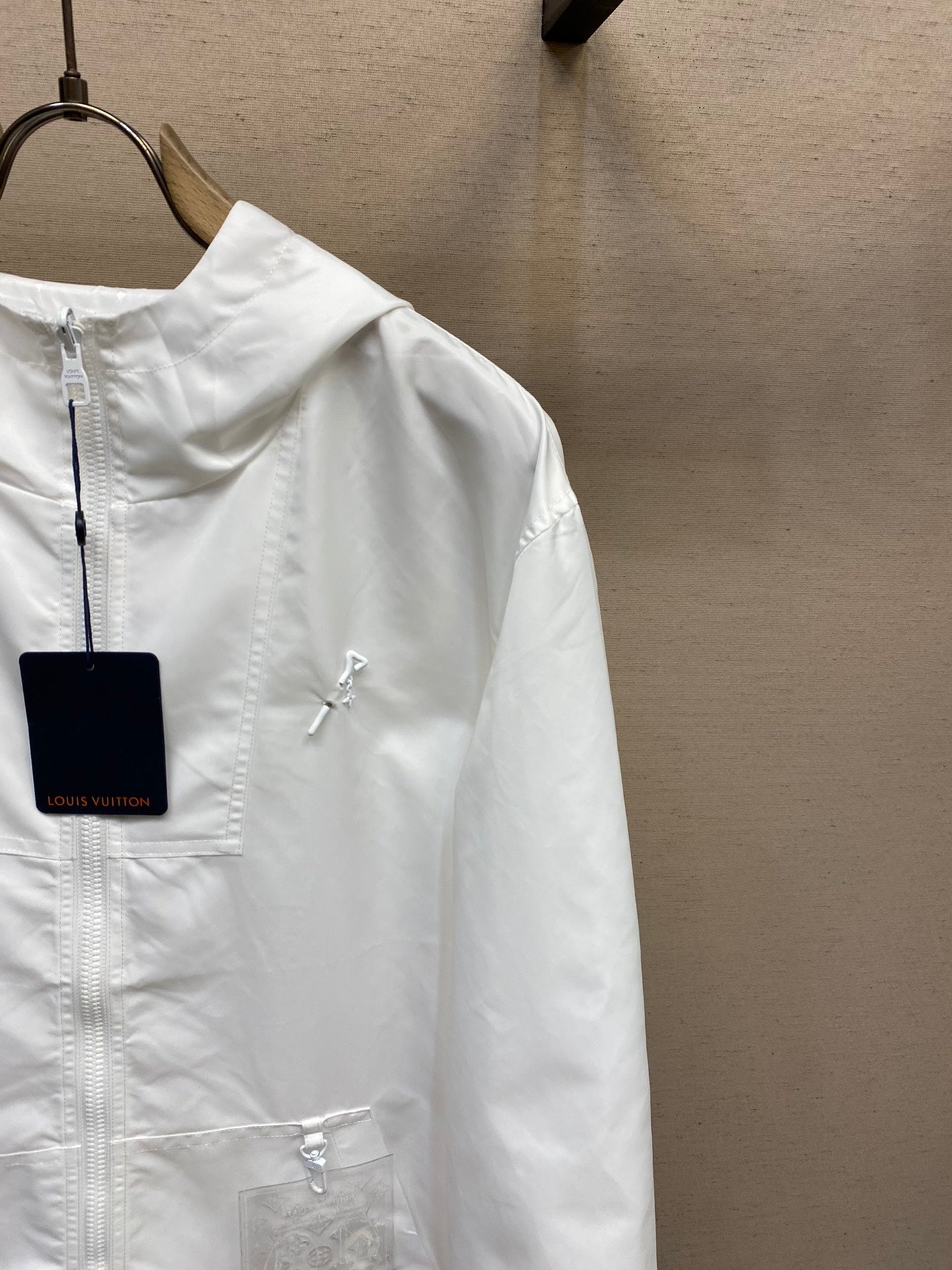 Louis Vuitton white hooded zip jacket close-up, front zipper and chest logo detail