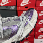 Unisex sneakers, side view with textured silver panels and purple trim
