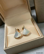 Bvlgari earrings in box: gold half-moon studs with iridescent white panels.