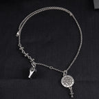 Silver-tone charm necklace with round medallion pendant, star accents, and dangling detail