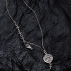 Silver-tone charm necklace with round medallion pendant and fleur-de-lis link accents