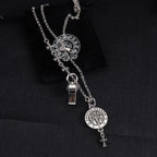 Silver-tone charm necklace with round medallion, fleur-de-lis motifs, and small metal lock charm