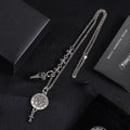 Silver-tone charm necklace with round medallion pendant and fleur-de-lis dangle details