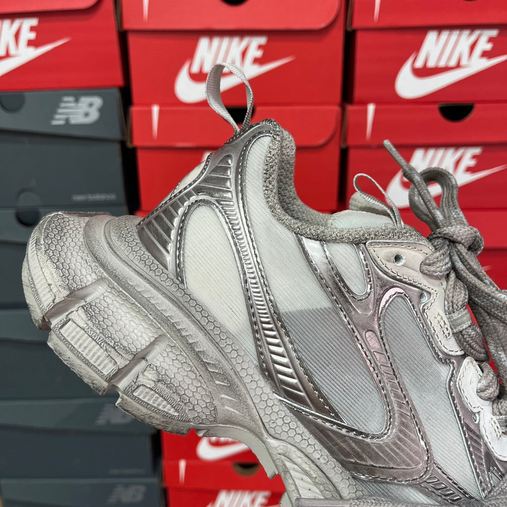 Silver metallic unisex sneakers with lace-up front, cushioned tongue, and chunky platform sole.