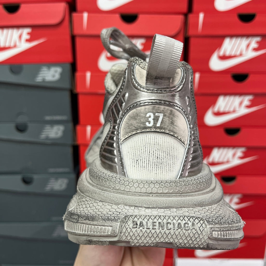 Silver metallic sneaker heel with logo patch, padded collar, and textured rubber outsole.