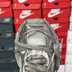 Silver metallic sneaker front with woven toe box, lace eyelets, and padded collar.