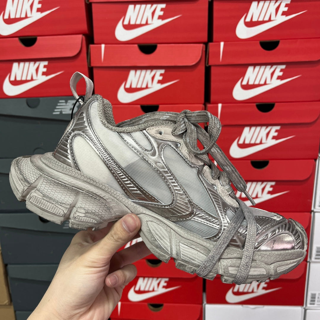 Silver metallic unisex lace-up sneakers with textured panels and thick sculpted sole.