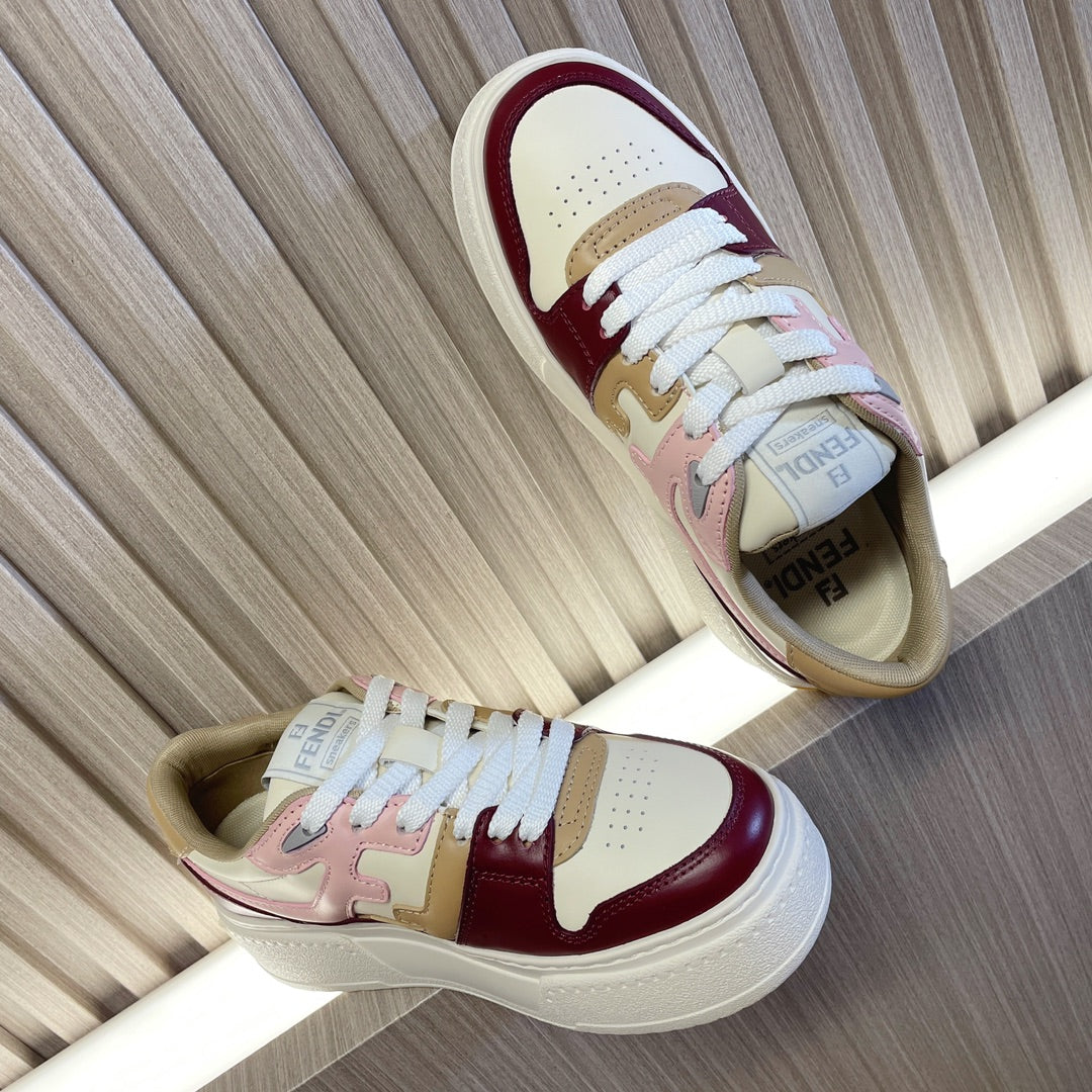 Low-top colorblock sneakers, white laces, burgundy and blush accents, side profile view