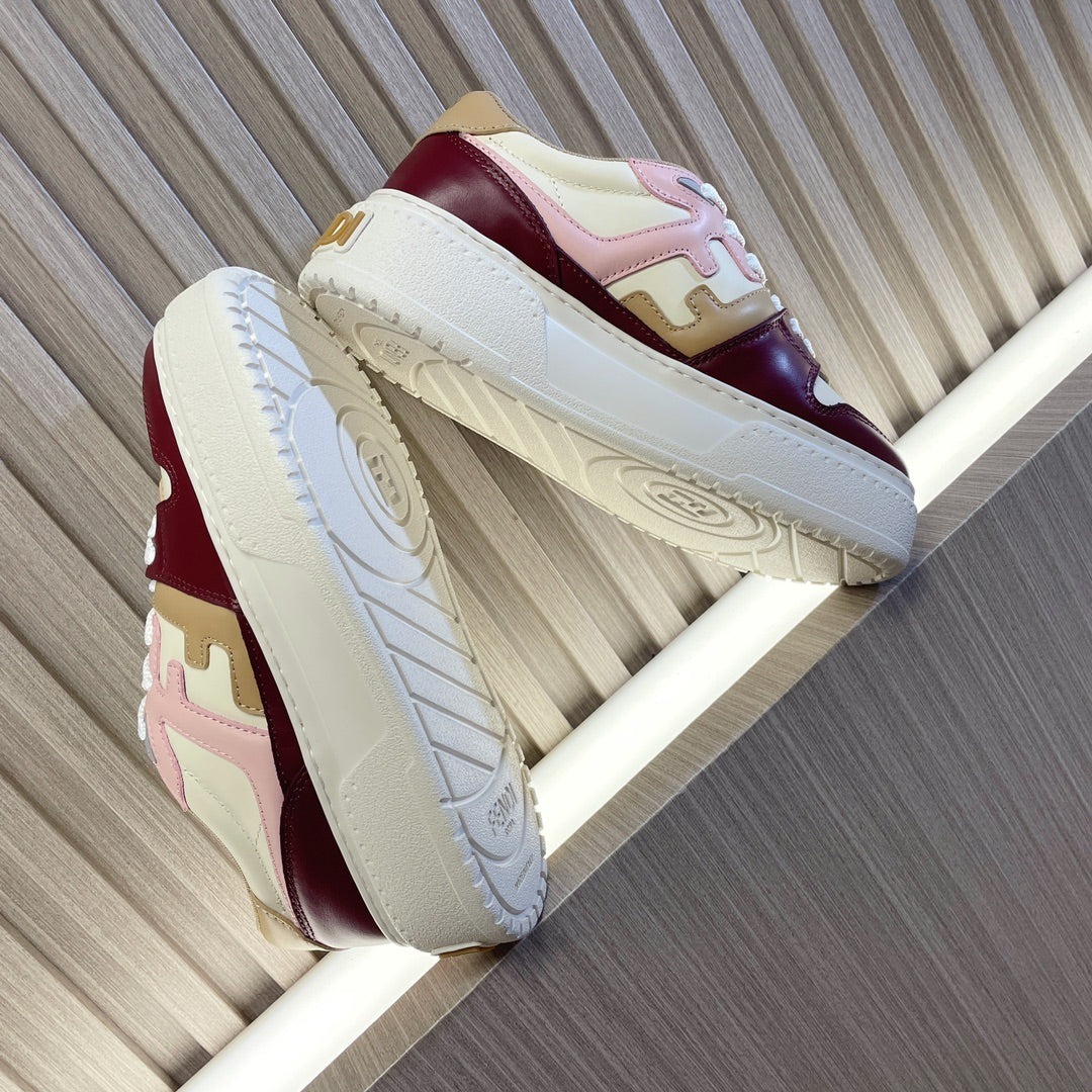 Colorblock sneakers shown from the side, white sole, burgundy leather with light accents