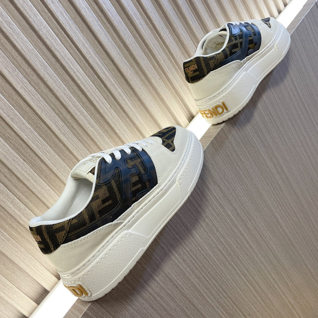 Low-top sneakers with white leather, dark logo side panels, and white rubber sole.