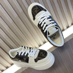 Pair of low-top sneakers with white laces, dark logo uppers, and cream sole.