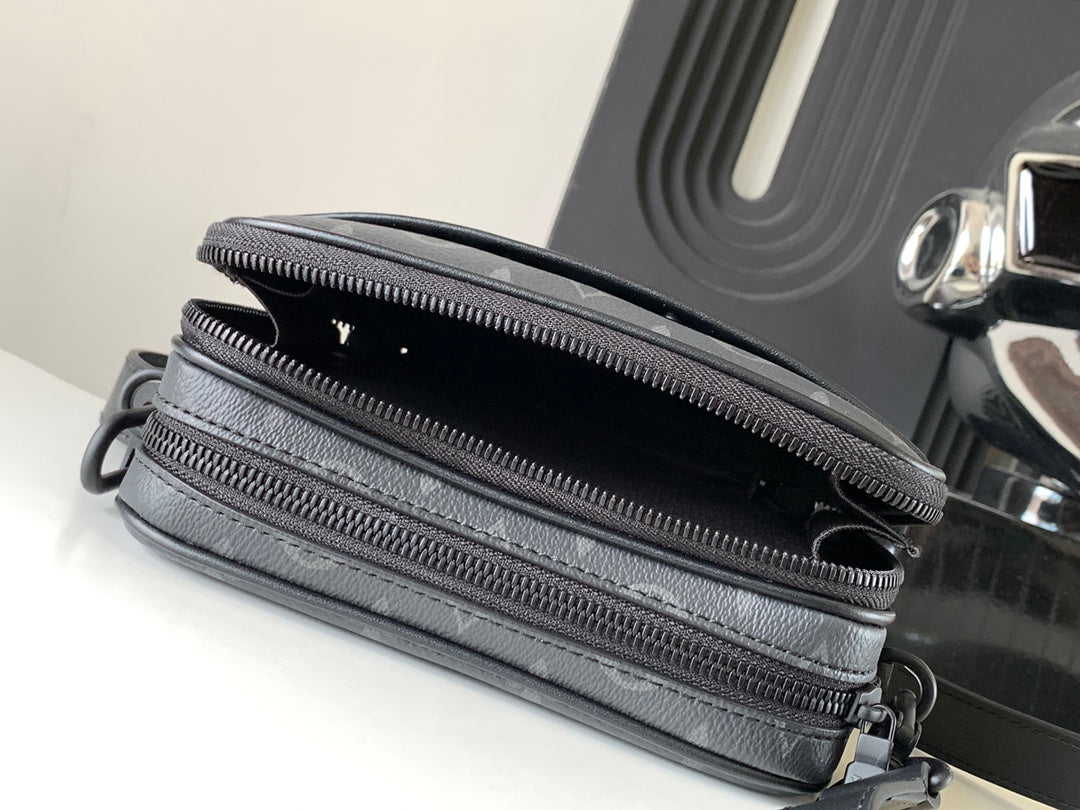 Dark gray crossbody bag with dual top zippers and monogram canvas panel