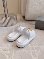 White slide sandals with gold BB buckle strap, angled view