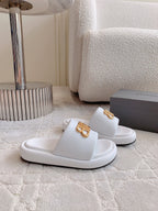White slide sandals with gold BB buckle logo on footbed