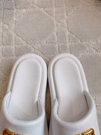 White slide sandals with gold BB logo details, front view