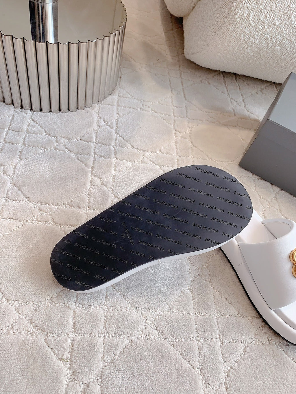 Dark underside of white slide sandals with flat rubber sole