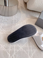 Dark underside of white slide sandals with flat rubber sole