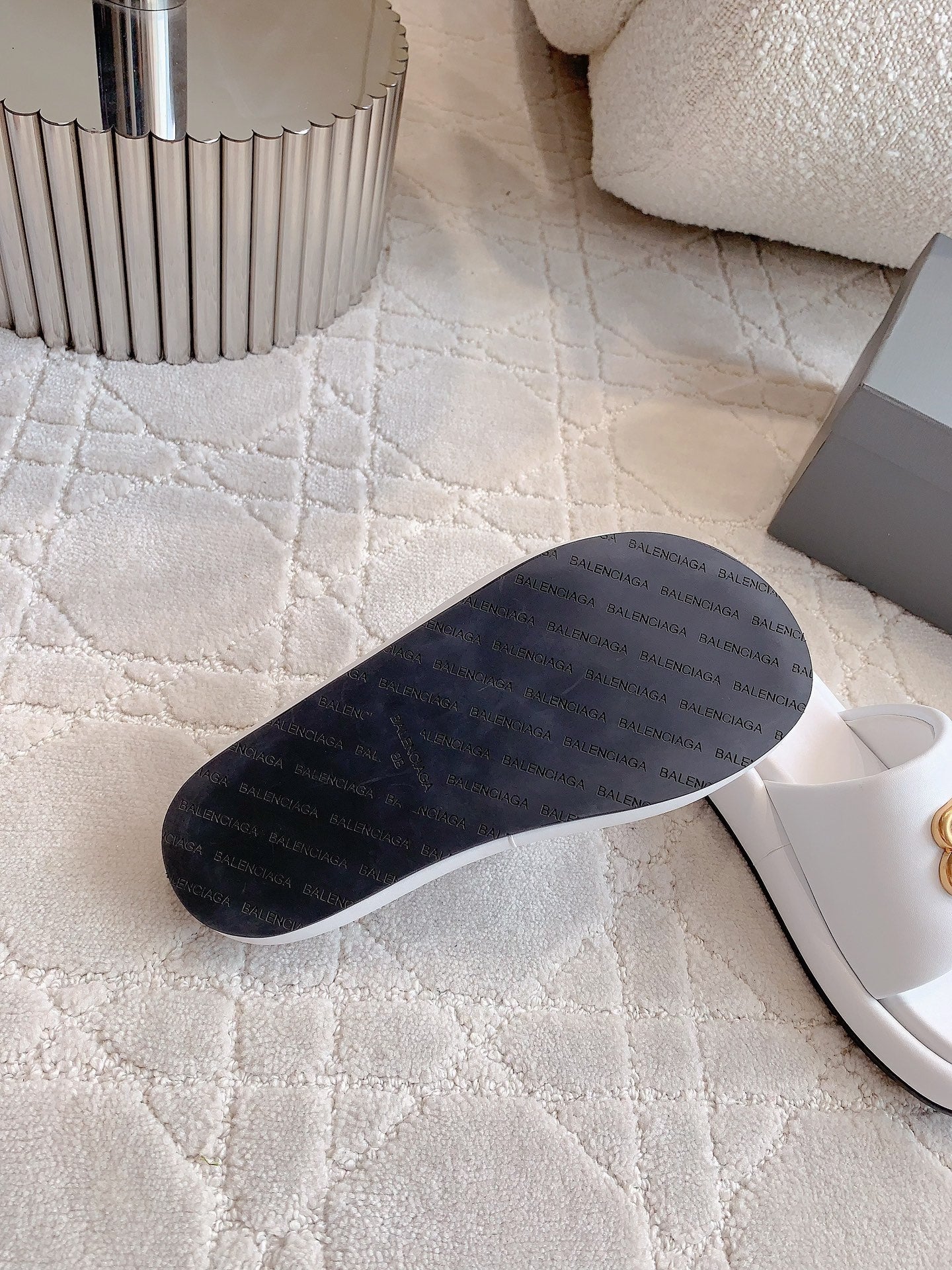 Dark underside of white slide sandals with flat rubber sole