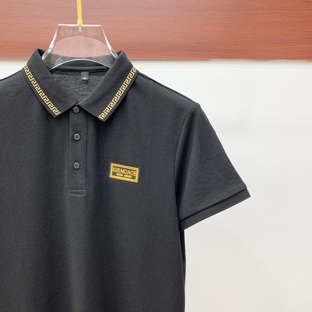 Black polo shirt with short sleeves and gold logo badge on chest