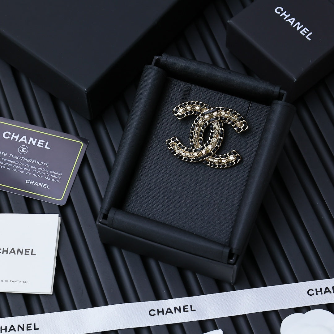 Chanel link chain bracelet on black display cushion, oval logo charm