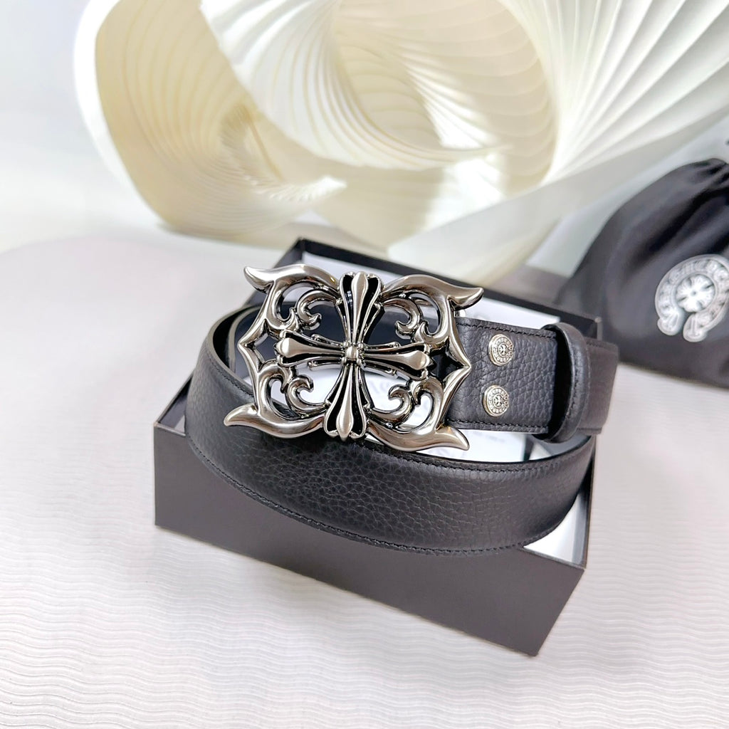 Dark leather belt with large ornate silver-tone buckle on a box