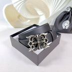 Dark leather belt with ornate silver-tone buckle resting in a box