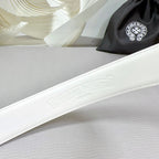 White leather belt with embossed logo detail along the strap