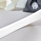 White leather belt with subtle embossed logo on strap