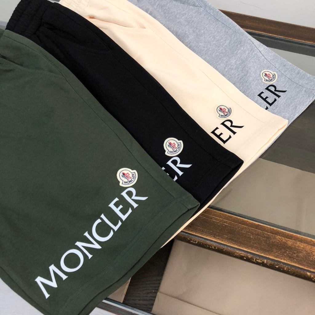 Folded shorts in dark green, black, and heather gray with MONCLER logo lettering