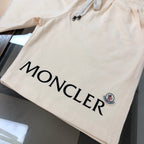 Cream shorts with large black MONCLER logo and small crest patch