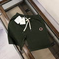 Dark green drawstring shorts with elastic waist and heart-shaped patch logo