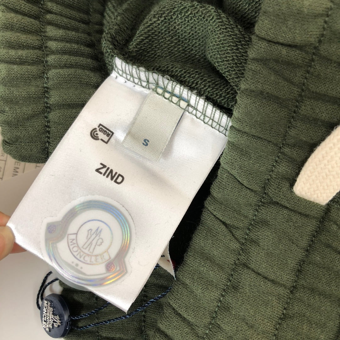 Dark green shorts label area with size tag 'ZIND' and Moncler branding