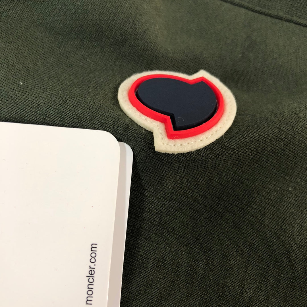 Heart-shaped patch applique on dark green shorts with red edging