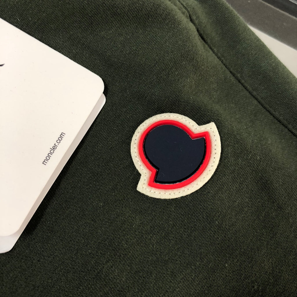 Heart-shaped patch applique with red outline on dark green shorts